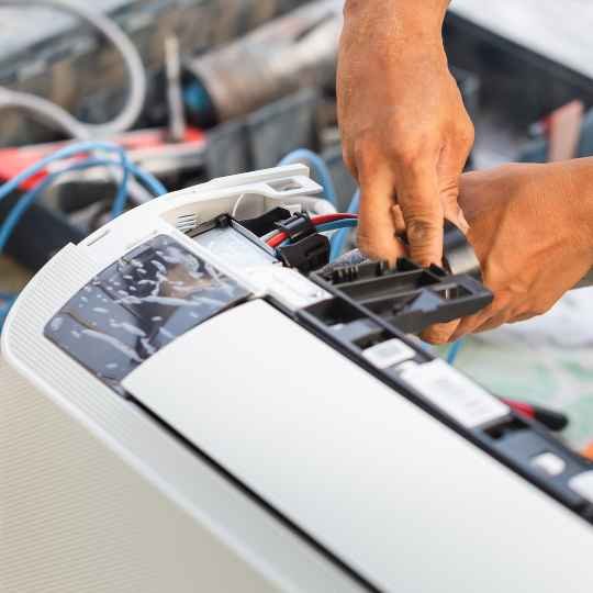 ac technician's hands repairing air conditioning system in summerwood