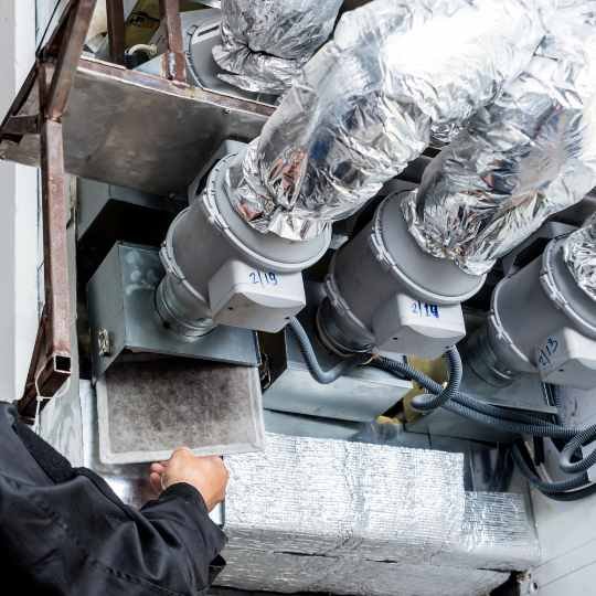 technician providing HVAC services on large HVAC system